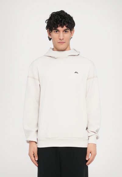 Sweat à capuche gris clair à coupe décontractée, présentant un petit logo noir sur la poitrine et des accents horizontaux subtils sur les manches.