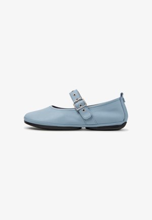 Lichtblauwe platte schoen met een afgeronde neus, verstelbare band met zilveren gesp en zwarte zool.