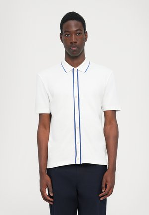 Hvid polo skjorte med en blå stribe langs knapperne, der har en klassisk krave og korte ærmer. Glat tekstur, letvægtsmateriale.