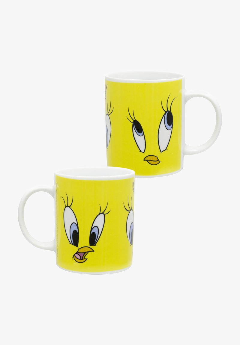 Tazza in ceramica con uno sfondo giallo brillante decorato con volti di personaggi dei cartoni animati, grandi occhi e beccucci definiti, manico bianco e superficie liscia.