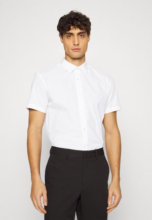 Kortarmig wit shirt in katoenmix, met een standaard kraag, knoopsluiting aan de voorkant en een gladde textuur, gecombineerd met zwarte broek.