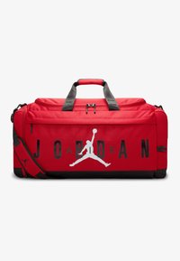 Piros szövet sporttáska fekete kiegészítőkkel. Nagy 'JORDAN' logóval és Jumpman sziluettel rendelkezik. Rövid fogantyúkkal és levehető pánttal van ellátva.