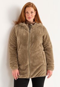 Jaket berlapis fleece, dengan ritsleting, berwarna taupe hangat, dilengkapi dengan penutup kepala, lengan panjang, dan finishing kain yang lembut serta bertekstur.