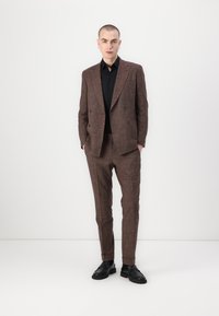 Costum dublu-broașat cu model maron, cu o croială ajustată, asortat cu o cămașă neagră și pantofi negri. Textură netedă, design modern.
