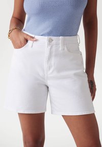 Witte denimshorts met een hoge taille, vijf-pocket ontwerp en een nette afwerking. Voorzien van een metalen knoopsluiting en een textuurstof.