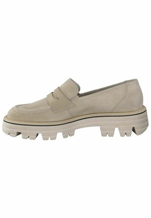 Chaussure slip-on en suede beige avec une tige texturée, une semelle épaisse à stries et deux brides superposées sur le devant. Accentuée de bordures noires.