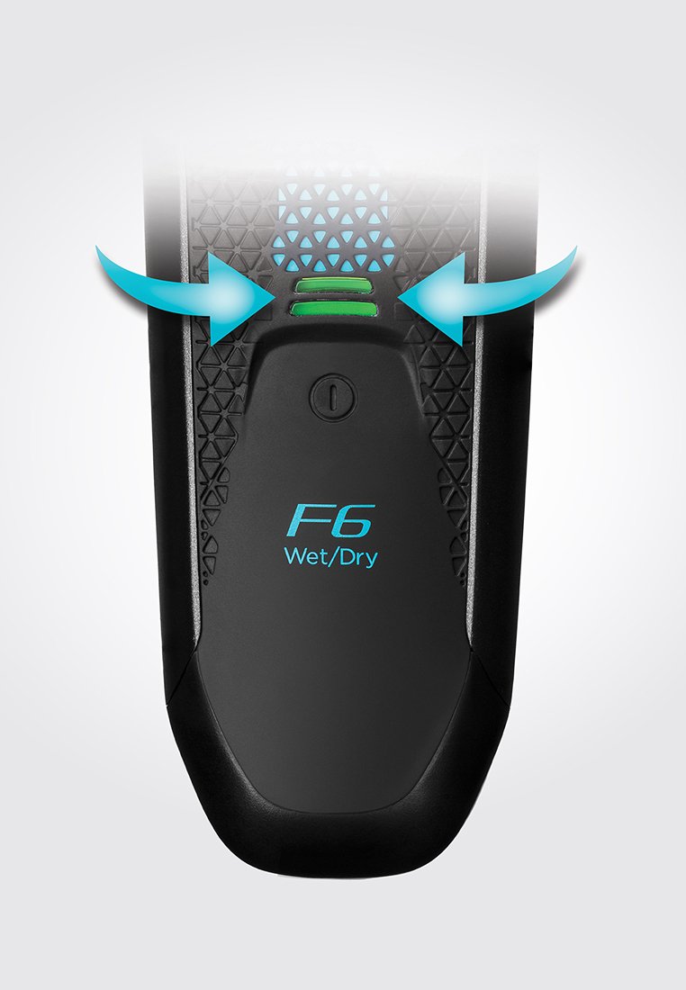 Afeitadora eléctrica negra con agarre texturizado, luces indicadoras verdes y azules, modelo "F6" y etiqueta "Húmedo/Seco", con un acabado brillante.