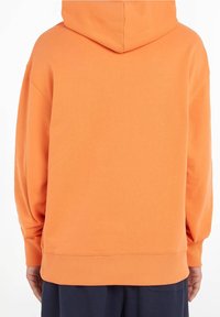 Oranje hoodie met een grote capuchon, geribbelde manchetten en zoom. Gemaakt van zachte stof, biedt een losse pasvorm en een minimalistisch ontwerp.