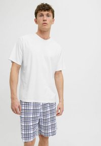 White short-sleeve t-shirt paired with blue and white checkered swim shorts featuring a grid pattern and side pockets.