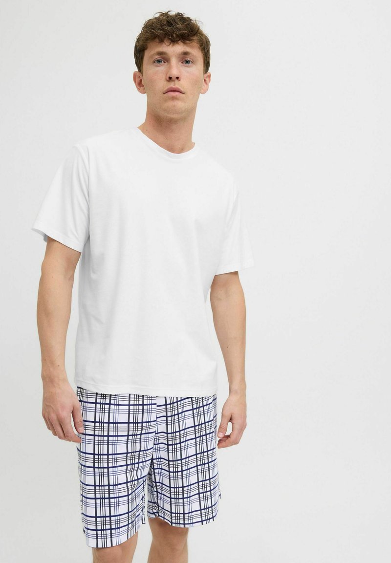 White short-sleeve t-shirt paired with blue and white checkered swim shorts featuring a grid pattern and side pockets.