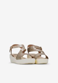 Sandales à talon compensé avec des brides en or métallique, design ouvert à l'avant, boucle ajustable à la cheville, semelle intérieure texturée et semelle légère et rembourrée.