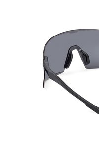 Czarne okulary przeciwsłoneczne z dużymi szarymi soczewkami, smukłymi ramionami i gumowymi akcentami. Oprawka ma minimalistyczny design z kanciastymi krawędziami.