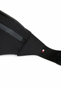 Borsa a tracolla nera con una finitura liscia e opaca. Presenta una tasca con cerniera, una tracolla testurizzata e un piccolo accento tricolore vicino alla fibbia.