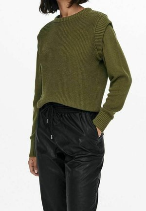 Pull en maille côtelée olive avec un col rond et des manches longues, associé à un pantalon en faux cuir noir avec des poches latérales et une taille à cordon.