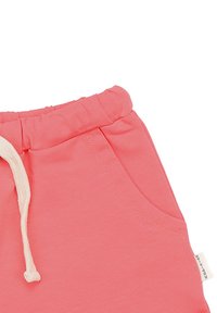 Pink cotton shorts with an elastic waistband, featuring a drawstring and side pockets. Includes a small branded label on the side.