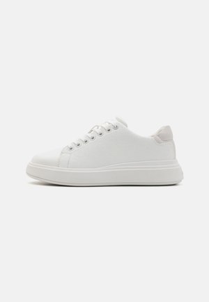 Weiße Sneakers mit einem strukturierten Obermaterial aus Canvas, runder Zehenform und Gummisohle. Sie verfügen über eine Schnürung und einen weichen, akzentuierten Fersensteg.