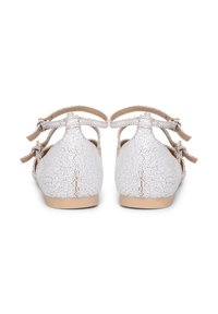 Ballerine in pelle bianca screpolata con due cinturini laterali con fiocchi. Il design presenta una punta arrotondata e una suola beige.