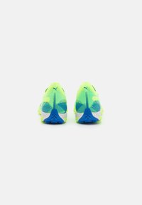 Zapatillas de running amarillas neón con parte superior de malla, acentos azules, suela texturizada y forma aerodinámica. Presenta detalles de diseño únicos en la parte trasera.