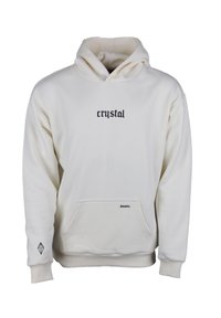 Sudadera blanca con un bolsillo frontal, que presenta la palabra "crystal" en fuente negra en el pecho, y un pequeño detalle de texto "dreams." cerca del bolsillo.