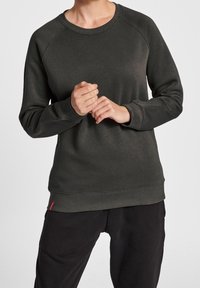 Felpa grigia scura con maniche lunghe a raglan, scollatura rotonda, polsini e orlo a costine. Presenta un piccolo tag rosso con il logo in basso.
