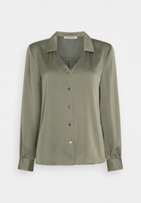 Blouse manches longues vert olive en tissu lisse, dotée d'un col en V, d'une patte de boutonnage à l'avant et d'un détail froncé. Les poignets sont légèrement froncés pour l'ajustement.