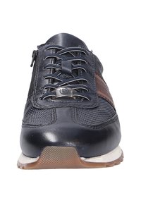 Baskets en cuir noir avec panneaux en mesh, bout rond, semelle en caoutchouc plate, bande brune contrastante et laçage à l'avant avec quincaillerie en argent.