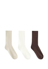 Drei Paar Socken bis zur Mitte der Wade: beige, weiß und dunkelbraun. Jede hat eine glatte Textur und ein einfaches Design ohne Muster oder Verzierungen.