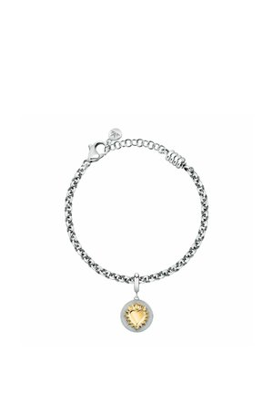Bracciale a catena in argento con pendente rotondo con un cuore dorato circondato da raggi di sole al centro.
