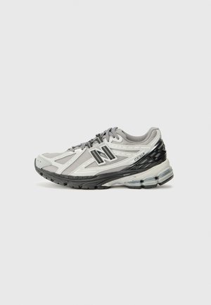 Chaussure de course pour homme en gris clair et noir, dessus en maille avec revêtements synthétiques, col rembourré et semelle amortie avec unités d'air apparentes.
