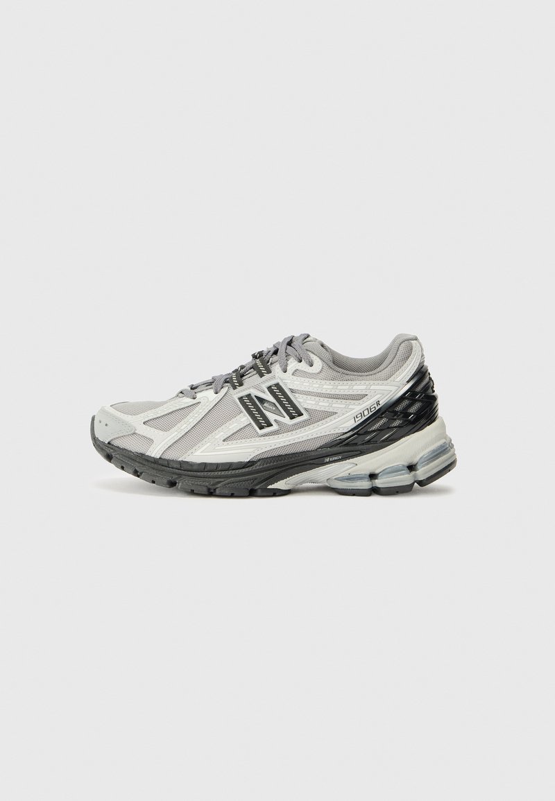 Chaussure de course pour homme en gris clair et noir, dessus en maille avec revêtements synthétiques, col rembourré et semelle amortie avec unités d'air apparentes.