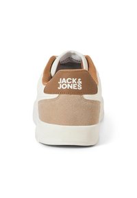 Weißer Sneaker mit braunem Wildleder-Fersenbereich und hellbraunen Akzenten. Verfügt über einen gepolsterten Kragen, strukturierte Materialien und ein Logo auf der Ferse. Gummisohle.