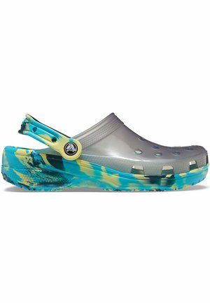 Sabots gris translucides avec semelles marbrées bleu et jaune. Dotés de trous de ventilation et d'une bride de talon ajustable pour un maintien sûr.