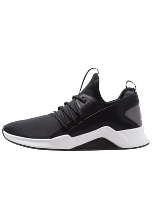 Czarny sportowy sneaker z białą podeszwą, sznurowaniem i wysokim kołnierzem przy kostce przypominającym skarpetę, pokazany z boku na białym tle.