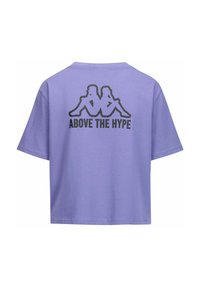 T-shirt in cotone viola con vestibilità rilassata, caratterizzato da una grafica nera di due figure e dal testo "ABOVE THE HYPE" sul retro.