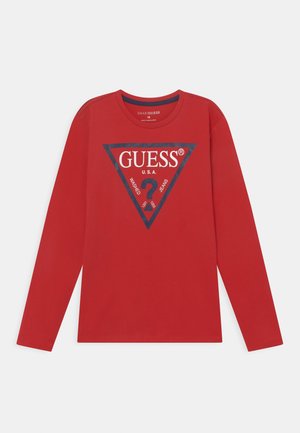Rotes Langarm-T-Shirt mit einem dreieckigen marineblauen Grafikdesign, das "GUESS" und weiteren Text zeigt. Aus weicher Baumwolle gefertigt, mit Rundhalsausschnitt und geradem Saum.