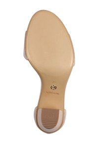 Semelle de chaussure beige avec une adhérence en caoutchouc texturé, forme légèrement incurvée et une empreinte de logo. Finition lisse globale avec un design épuré et minimaliste.