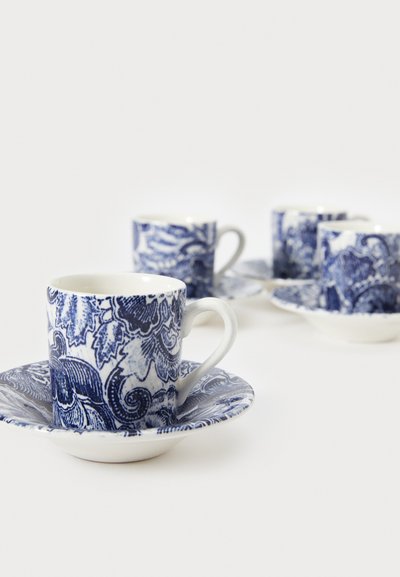 Set di quattro tazze da espresso e piattini in porcellana, con intricati motivi floreali blu su sfondo bianco, dotati di manici curvi.