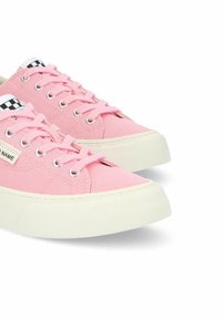 Le sneakers in tela rosa presentano un design a bassa misura, suole in gomma bianca e occhielli metallici, con accenti a scacchi sulla linguetta.