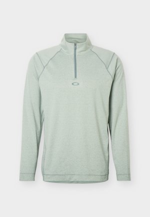 Lichtgroene pullover met lange mouwen en een kwart ritssluiting, voorzien van een klein ovaal logo gecentreerd onder de kraag, ontworpen voor casual of sportief gebruik.