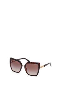 Brune tortoiseshell solbriller med overdimensionerte vinklet rammer, gradientlinser og gullkjede aksent på templene.