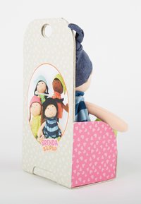 Bambola di stoffa morbida con abito e cappello blu, parzialmente inserita in una confezione di cartone rosa e bianca a tema cuori con immagini di bambole disegnate.