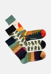 Drei Paare bunter Socken: ein grüner einfarbiger Bund, eine gemusterte weiße Basis mit schwarzen und grünen Designs und ein mehrfarbig gestreiftes Muster.