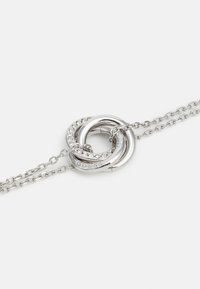 Collar de plata con tres aros entrelazados, dos pulidos y uno decorado con cristales transparentes, unido a una delicada cadena.