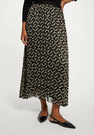 Gonna maxi con un motivo ondulato nero e crema, design plissettato e vita aderente, abbinata a ballerine nere a punta.