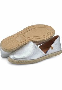 Zapatos plateados sin cordones con un brillo metálico, que cuentan con una parte superior suave, suela envuelta en yute y plantilla de goma texturizada.