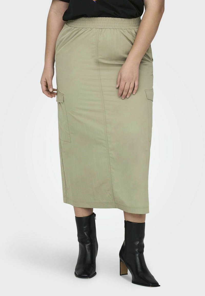 Khaki midi krilo z elastičnim pasom, stranskimi žepi in gladko teksturo, v kombinaciji s črnimi gležnjarji z blok peto.
