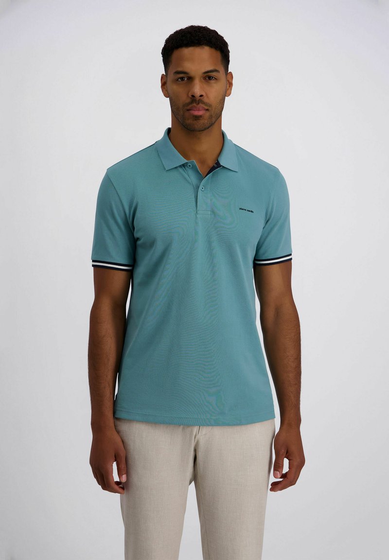 Hellblaues Poloshirt mit weicher Textur, ausgestattet mit einer Knopfleiste mit drei Knöpfen, kurzen Ärmeln mit schwarz-weiß gestreiften Akzenten und einem Logodetail.