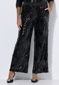 Zwarte sequin wijde broek met een textuurpatroon, voorzien van een gladde tailleband en zijzakken. Gepaard met zwarte schoenen versierd met een decoratieve accent.