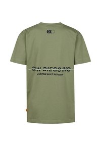 T-shirt manches courtes couleur vert olive avec encolure ronde. Présente un texte imprimé et des graphismes en bleu foncé au dos ainsi qu'une petite étiquette orange sur le côté.