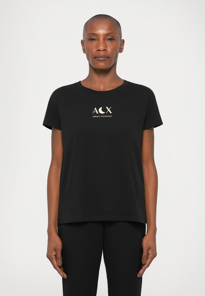 T-shirt preta em algodão com decote redondo, mangas curtas e um logótipo dourado com "ACX" e "Armani Exchange" ao centro.